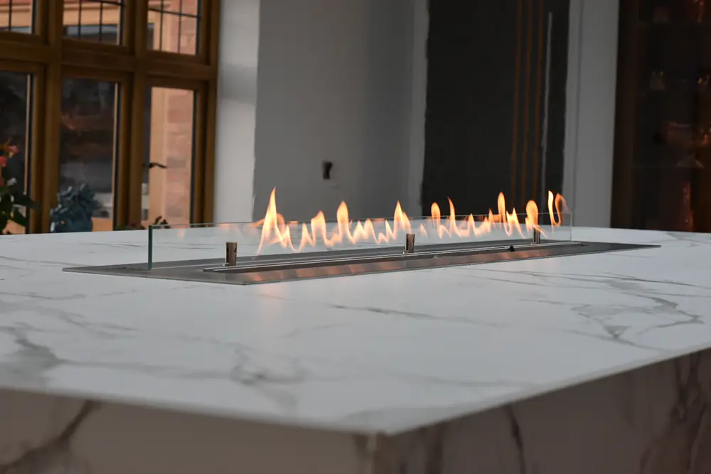 grey/white marble island worktop with flame feature in the middle