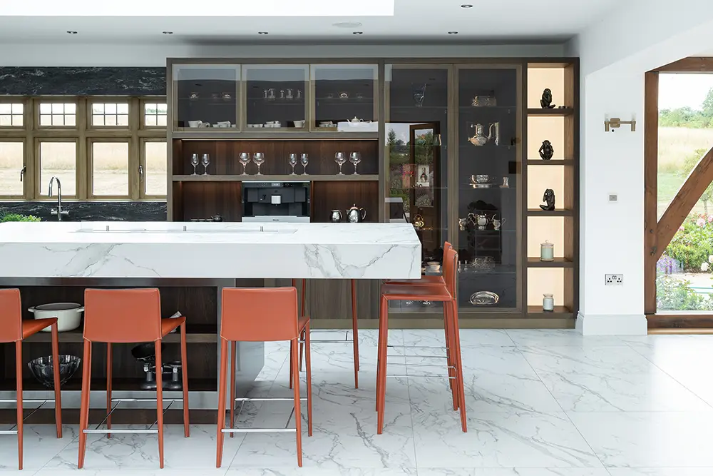 grey/white marble island worktop with flame feature in the middle with orange stools